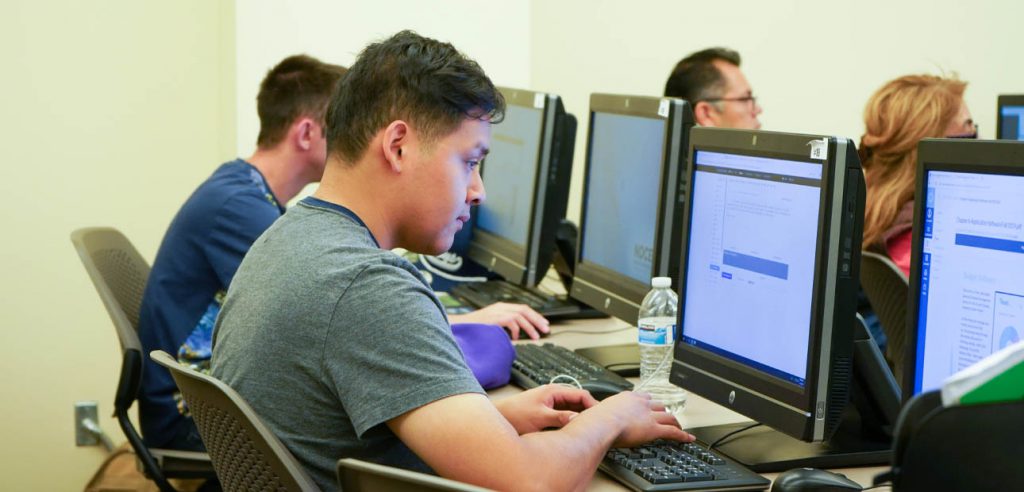 Una foto de un estudiante de NOCE trabajando en la computadora.