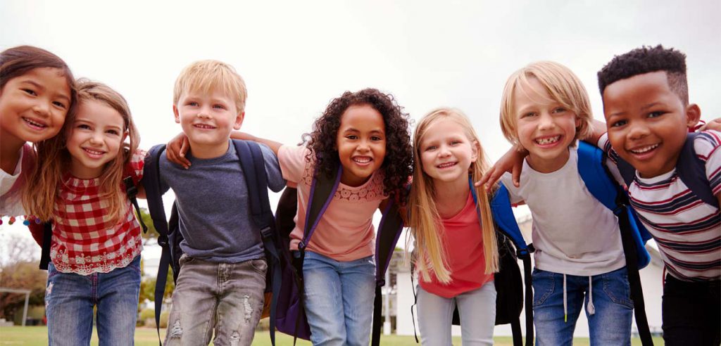 a group of smiling elementary school kids huddled together