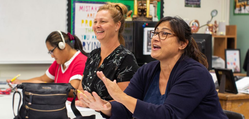 Parents laughing together in an in-person Love and Logic® class meeting.