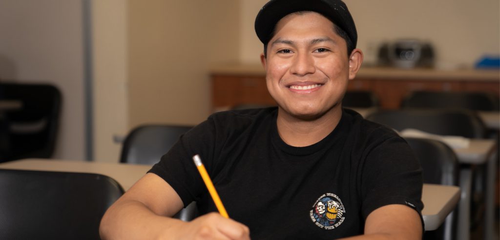 un estudiante de esl sonriente en el centro de aprendizaje de esl