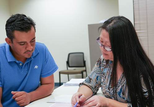 A photo of a tutor helping a student with their assignment.