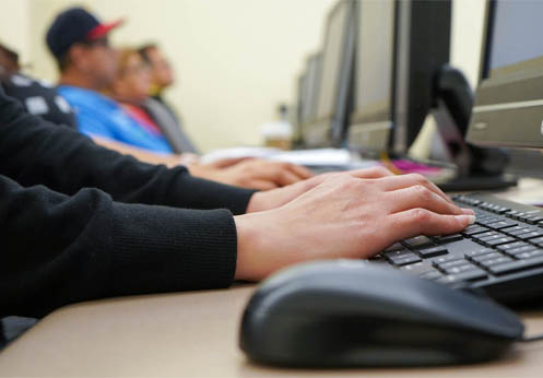 Una foto de las manos de un estudiante en un teclado.