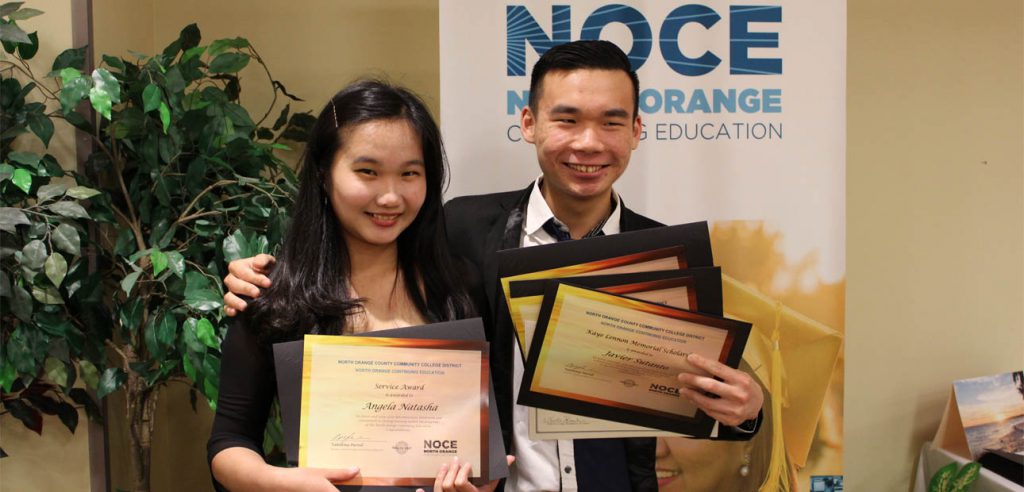 Dos de los ganadores del Premio de Becas NOCE 2018, posando para una foto con sus premios.