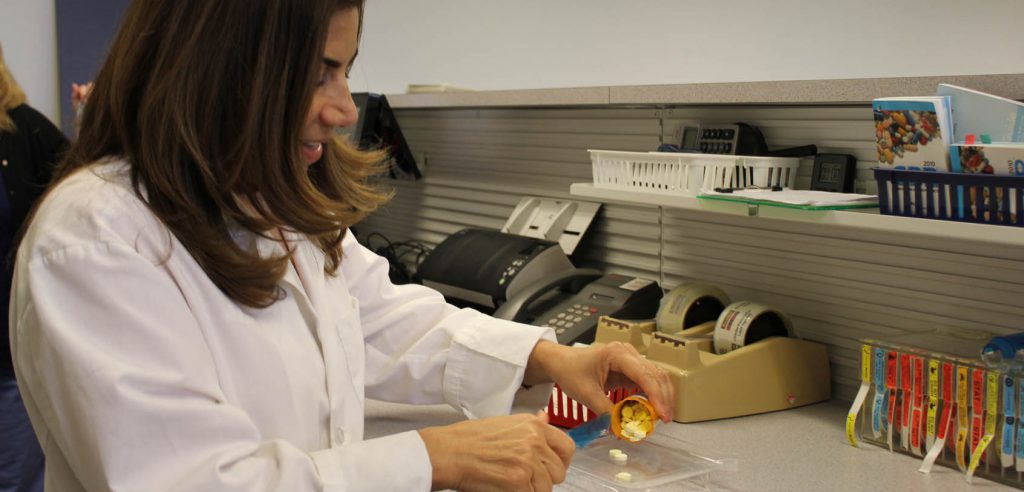A pharmacy technician student separating out the number of pills for one prescription. 