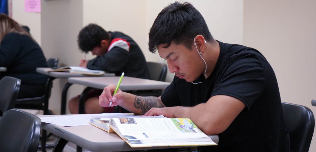 Un estudiante de NOCE estudiando su texto.