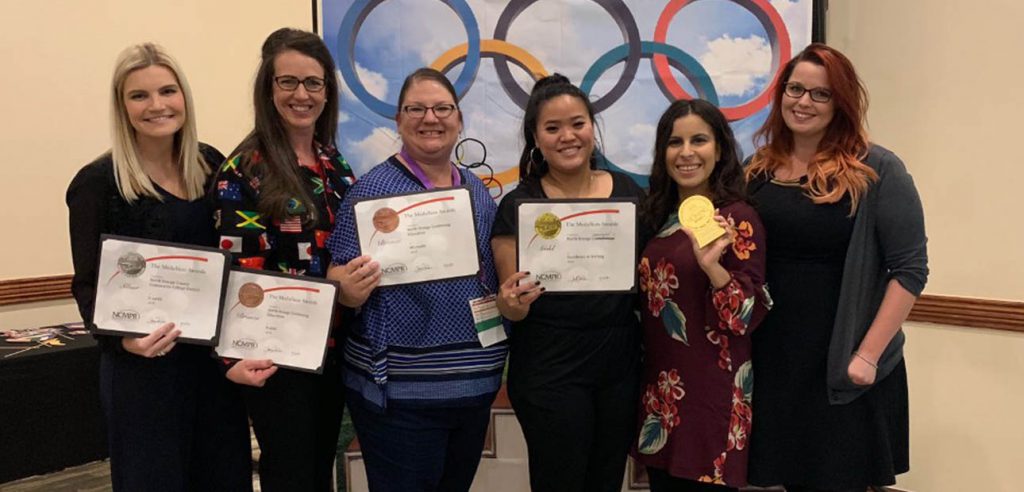 A photo of some of the members of the NOCE campus communications team winning 4 awards at the NCMPR event in 2019.