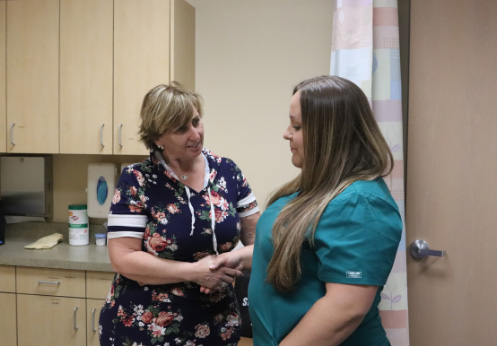 A caretaker and a patient shaking hands