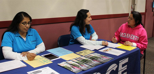 NOCE counselors sit at an outreach table