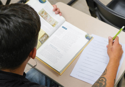 A student reading a textbook and taking notes
