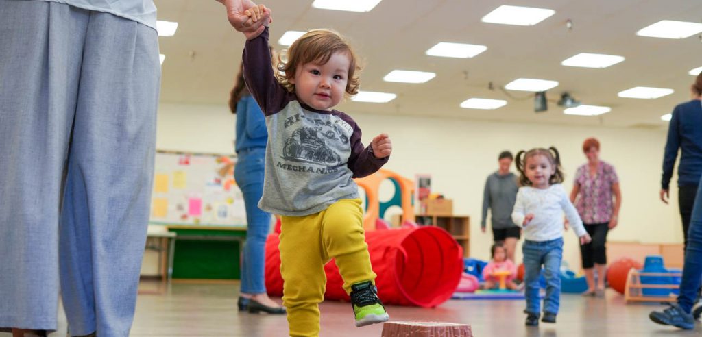 A photo of a baby learning to walk.
