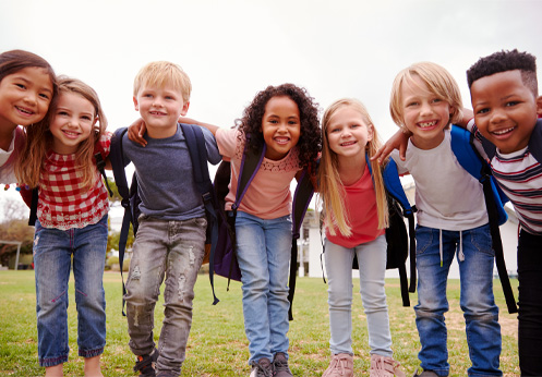 A group of smiling elementary school kids huddled together