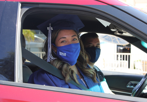Student in her cap and gown in the car.