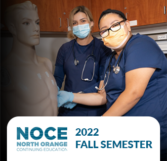 two medical assisting students posing for the camera next to a medical dummy