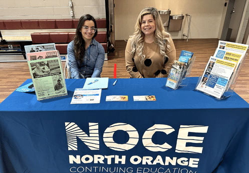 Anacany Torres and Rosemary Rangel posing at the NOCE table during an outreach event.