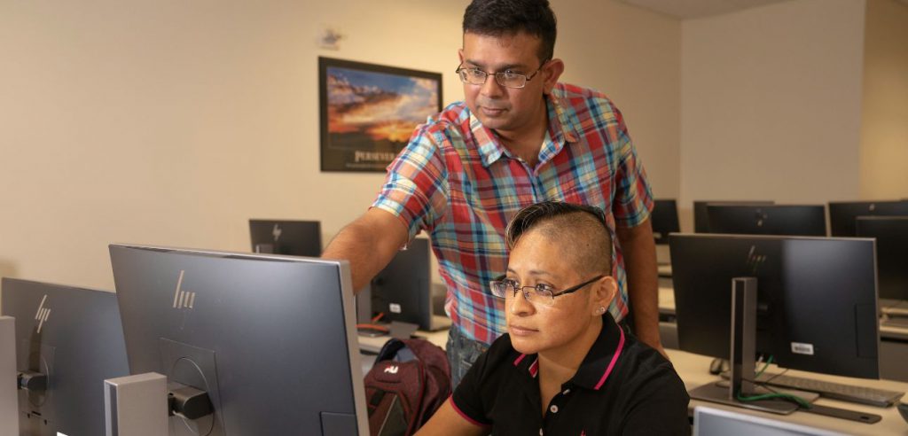 A teacher is helping a student navigate on their computer.