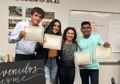 Four students holding up their ESL certificate of recognition