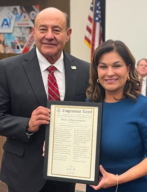 Congressman Lou Correa and NOCCCD Board President Evangelina Rosales holding the Congressional Record together
