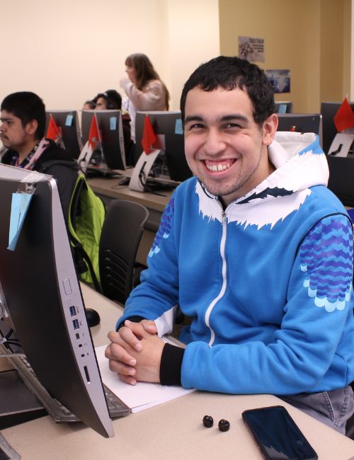 A smiling DSS male student with dark short hair, light complexion and wearing in a light blue and white yeti monster hoodie.