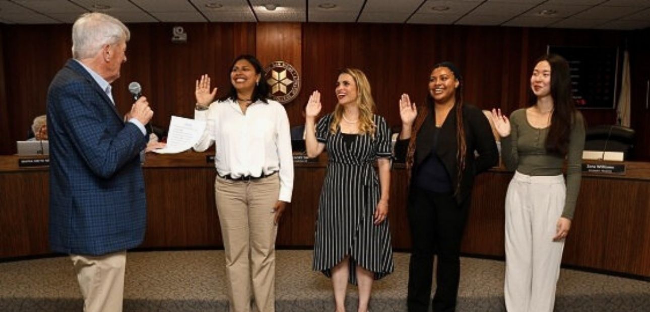 Board President Bernie Rhinerson swears in the four student trustees during the June 2024 Board of Trustees meeting.