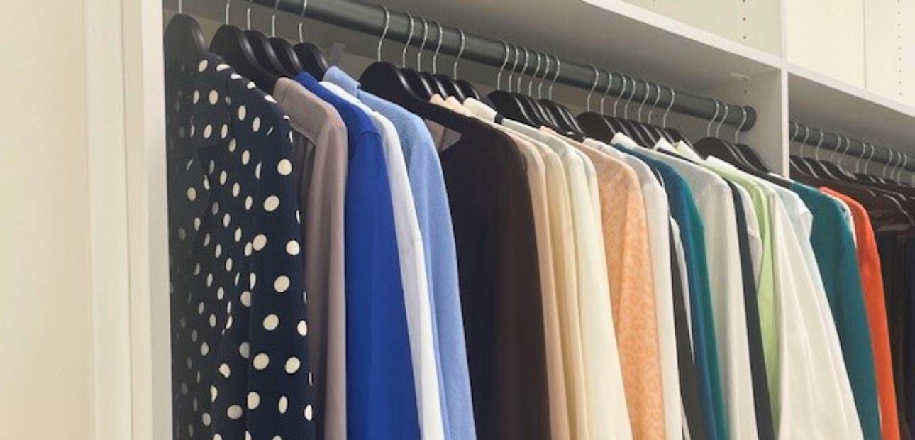 Clothing racks along a wall filled with various business attire.