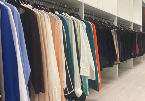 Clothing racks along a wall filled with various business attire.