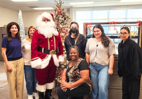 A group of NOCE Cypress Center Staff and Faculty posing with Santa Claus