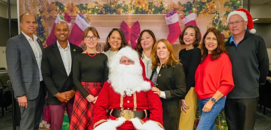 NOCCCD Chancellor's Staff posing with Santa Claus at the December 2025 Power Up Resource Fair