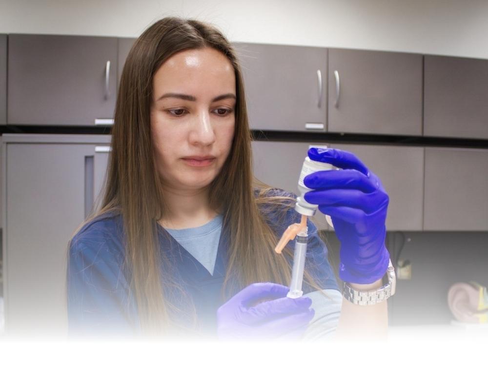 Medical Assistant student prepping an injection.