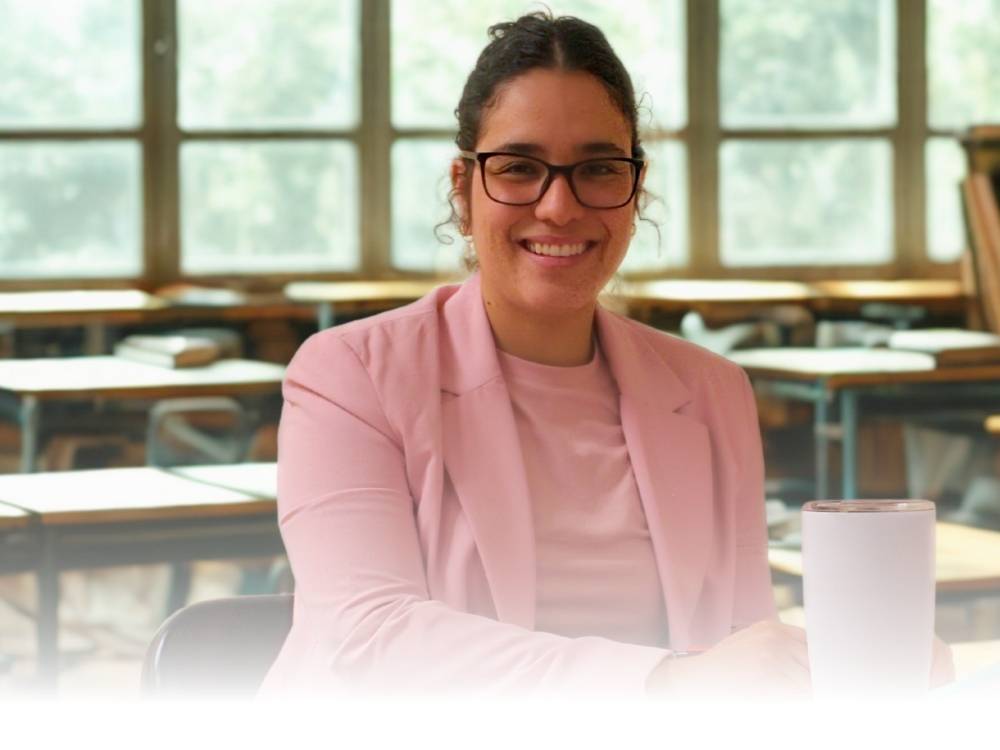 A smiling student in a pink blazer and a pink top to match.